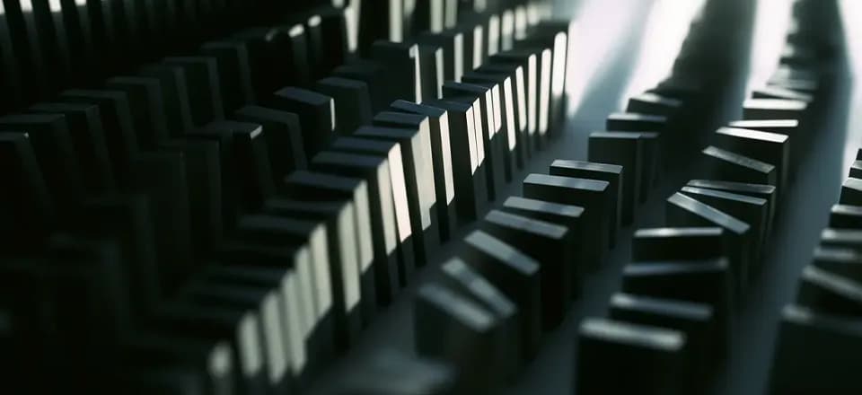 Das Finanzsystem scheint nach außen hin perfekt aufgestellt. Doch Dr. Markus Krall warnt: Wackelt der erste Dominostein – sei es durch eine Zinswende, kollabierende Zombieunternehmen oder eine Staatsanleihenkrise – könnte sich eine Kettenreaktion entwickeln, die niemand mehr kontrollieren kann. Aufgereihte Dominosteine, um das drohende Zusammenbrechen zu symbolisieren.
